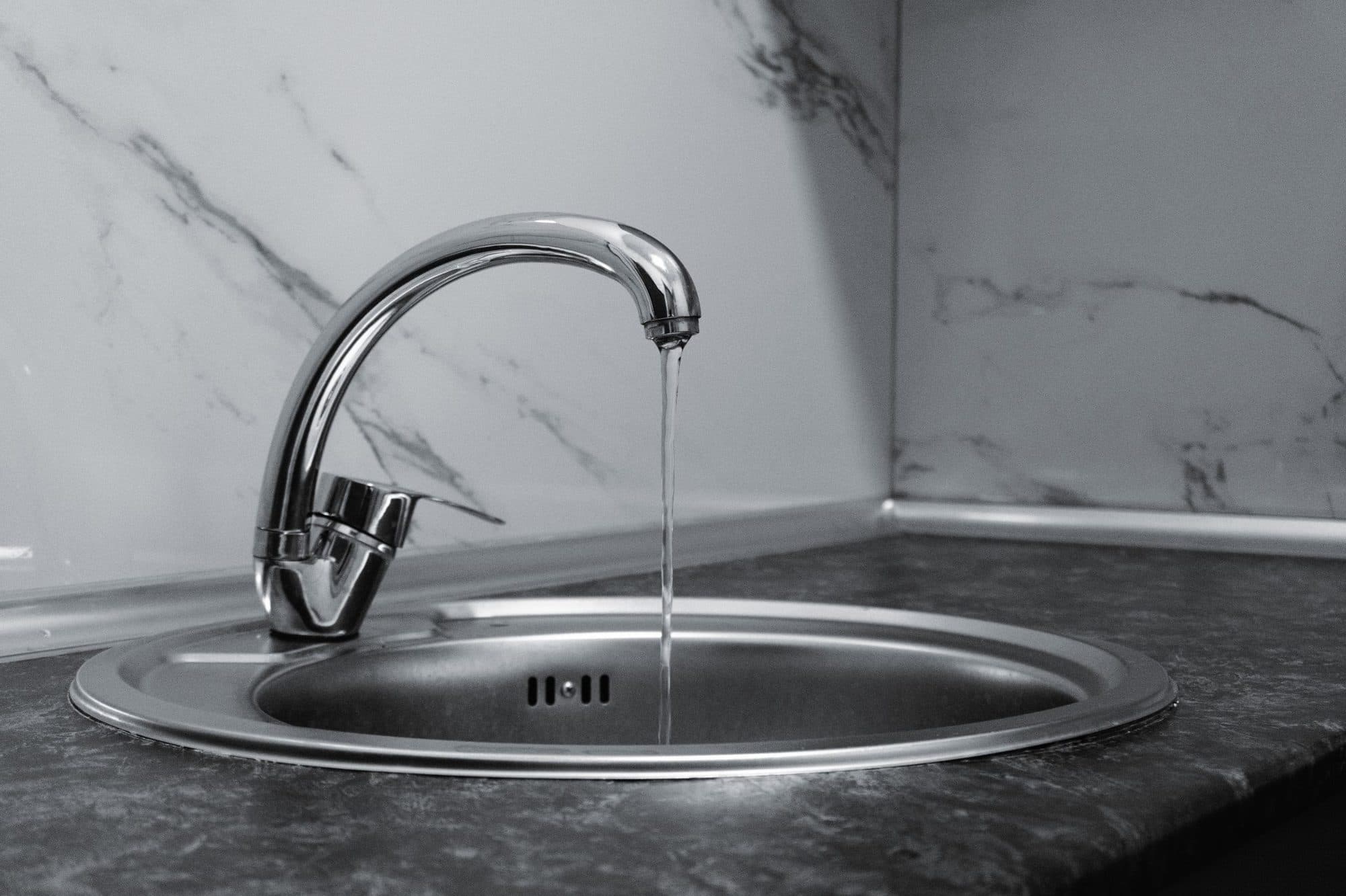 Water running from a chrome tap into a sink